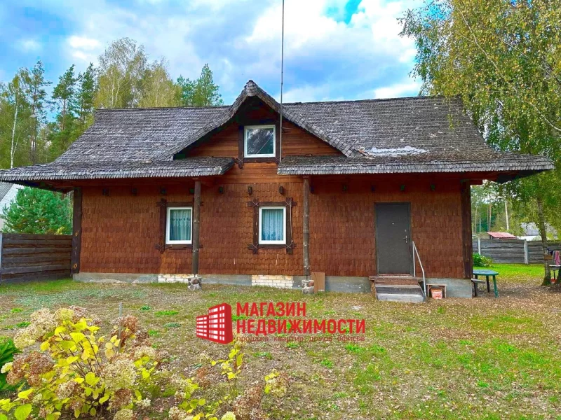 Деревянный дом с соломенной крышей, окруженный деревьями и зеленью - Хутор в деревне Загорники под Гродно.