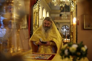 Священник протоиерей Сергий Баранов в богато украшенном желтом одеянии читает книгу в гродненском Свято-Покровском кафедральном соборе