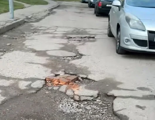 “Полнейший игнор двора”. Жители дома по улице Брикеля жалуются на разбитую дорогу в трещинах, дырах и ямах