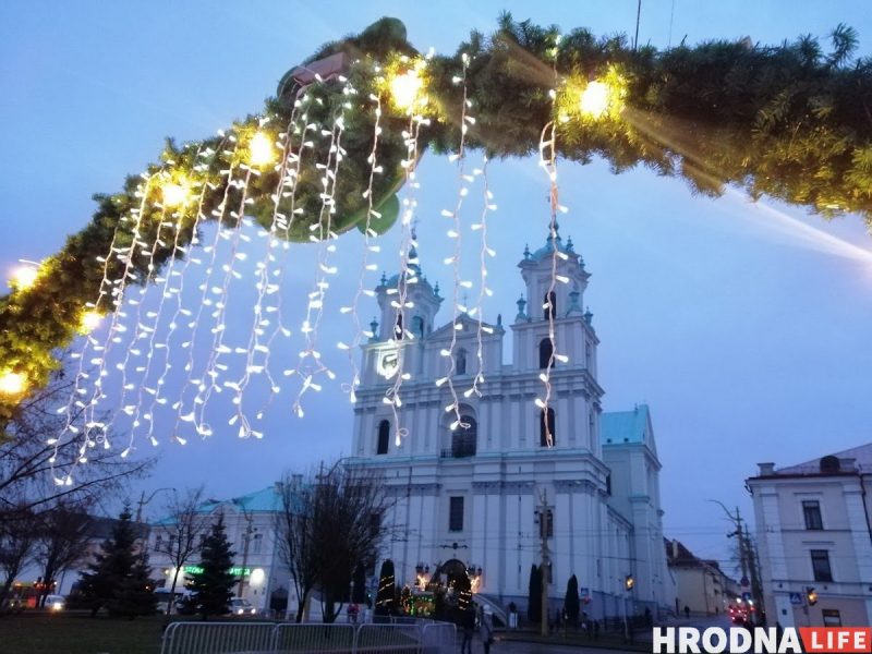 Царква з упрыгожанымі фасадамі прыгожа стаіць за асветленымі падвеснымі агнямі на святочнай арцы, нагадваючы пра ажыўленую атмасферу шумных рынкаў.
